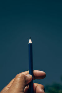 Close-up of hand holding blue background