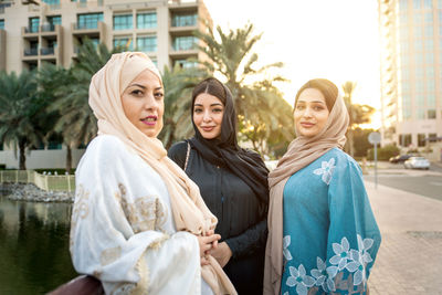 Portrait of young women in hijab standing on footpath