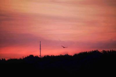 Scenic view of silhouette landscape against orange sky