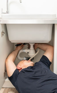 Midsection of man washing hands in bathroom