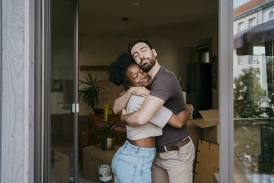 Romantic couple embracing each other with eyes closed at new home