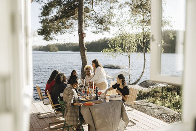 Cheerful female friends enjoying while having food at dinner party on sunny day