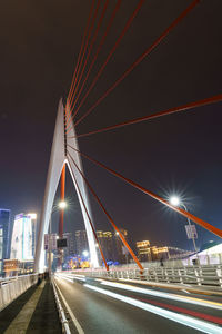 Light trails on road against sky at night