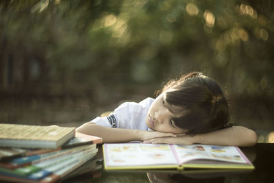 Close-up of girl leaning on desk while studying