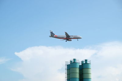 Low angle view of airplane flying against sky