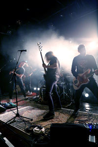 People playing guitar at music concert