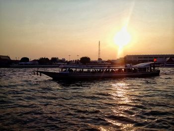 Boats in sea at sunset