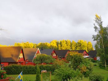 Houses and trees against sky