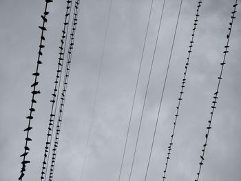 Low angle view of silhouette electricity pylon against sky