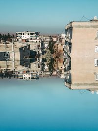 Buildings in city against clear blue sky