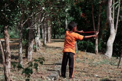 Rear view of man standing in forest