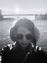 Portrait of young woman wearing sunglasses against sea