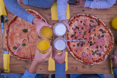 High angle view of woman holding pizza on table