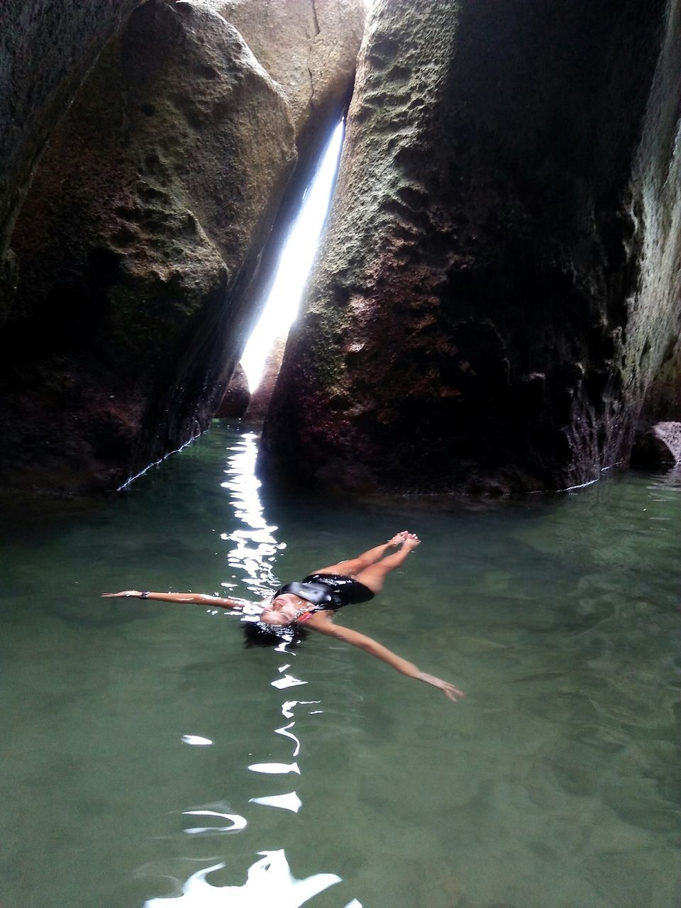 MAN SWIMMING IN RIVER WITH PEOPLE IN BACKGROUND