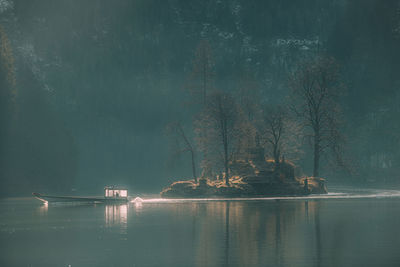 Scenic view of lake by trees against sky