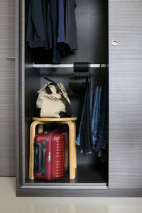 Luggage with stool and clothing in cabinet