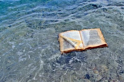 High angle view of an open book on sea shore