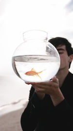 Man holding fish in glass