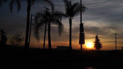 Silhouette of electricity pylon at sunset