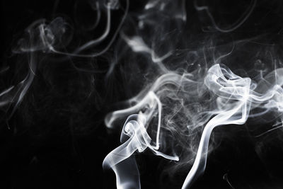 Close-up of smoke emitting from black background