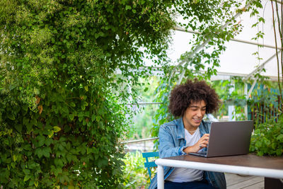 Young woman using laptop while sitting at park