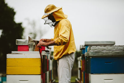 Beekeeper working over beehive at farm