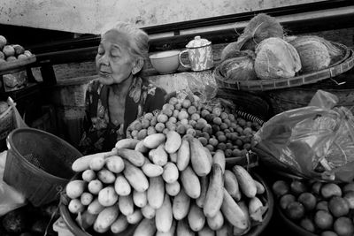 Senior woman selling vegetables in market