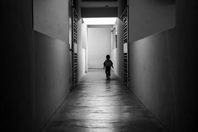 Rear view of boy walking in corridor