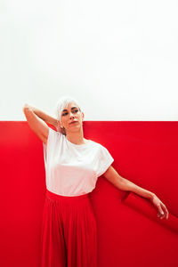 Full length of woman standing against red background