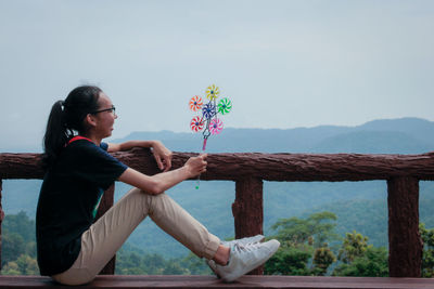 Side view of young woman sitting on steps