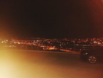 Illuminated city against sky at night