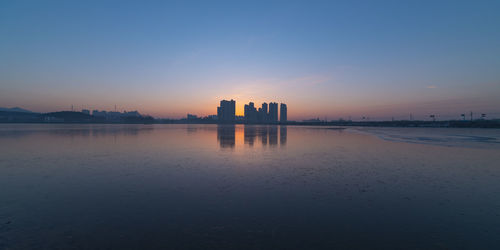 Scenic view of buildings against sky during sunset