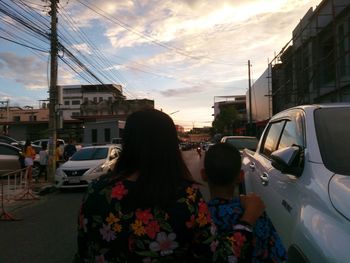 Rear view of woman on street in city against sky