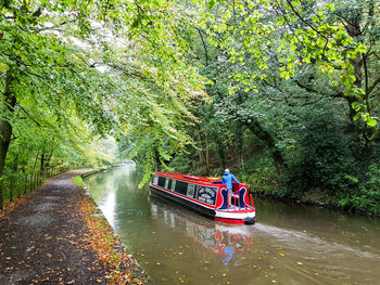 People on boat in river against trees