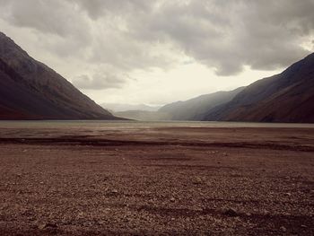 View of desert against cloudy sky