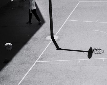 Low section of man playing basketball on sunny day