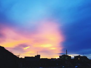 Low angle view of buildings against dramatic sky