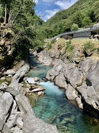 Scenic view of river by mountains against sky