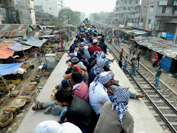 People sitting on train rood in city