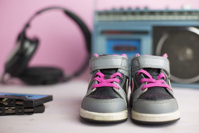 Close-up of shoes by cassette player and headphones on table