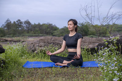 Portrait of young man sitting on field
