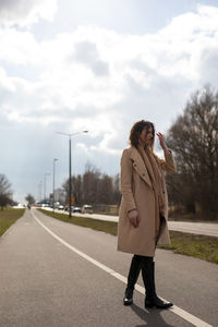 Woman standing on road against sky