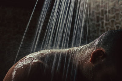 Close-up of man taking shower