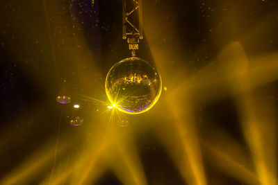 Low angle view of disco ball in illuminated nightclub