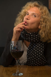 Portrait of woman with drink sitting at restaurant