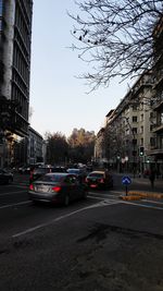 Cars on road against sky in city