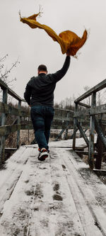 Rear view of man standing on snow