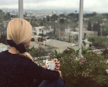 Rear view of woman with cityscape in background