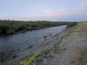 Scenic view of river against sky during sunset