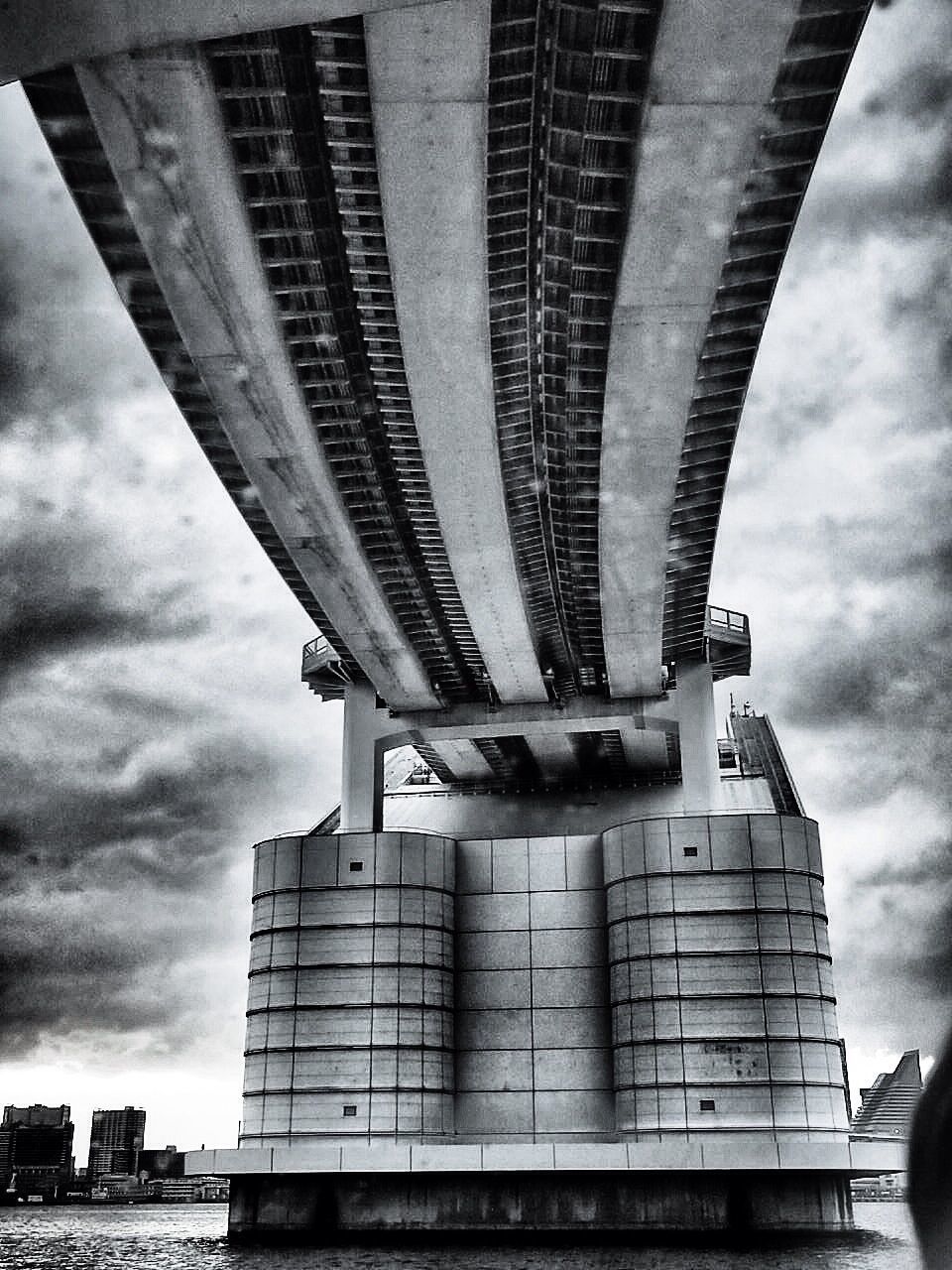 architecture, built structure, building exterior, sky, low angle view, cloud - sky, cloudy, bridge - man made structure, city, connection, modern, building, cloud, outdoors, day, no people, engineering, architectural column, overcast, office building